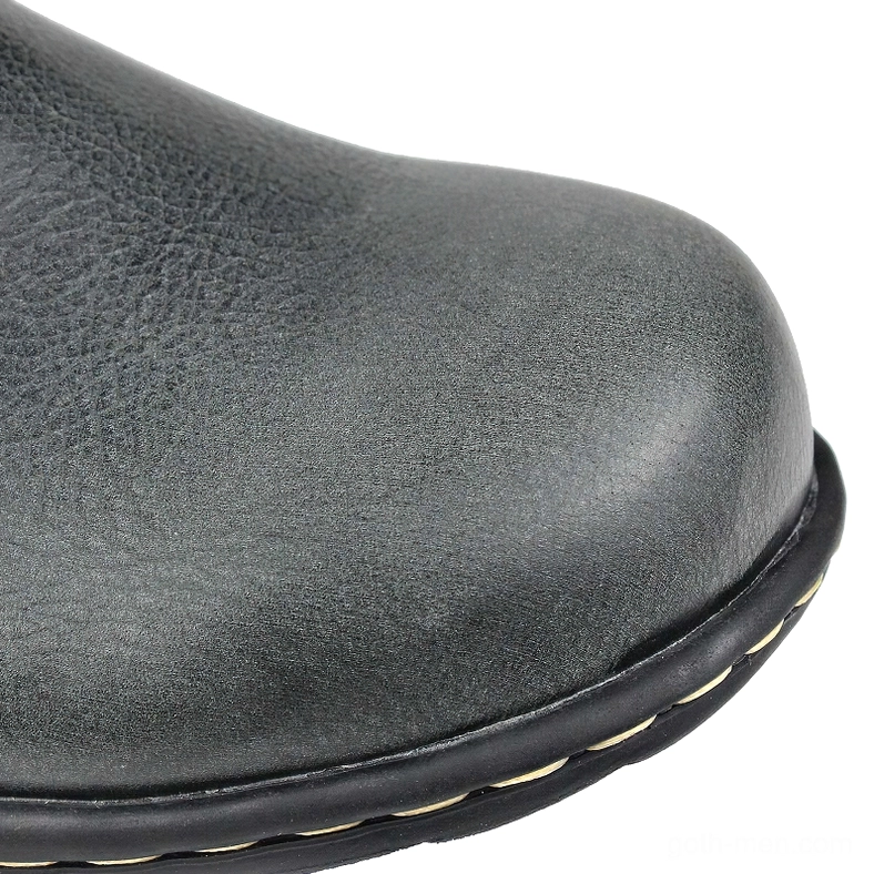 Gothic boot toe and rubber outsole close-up showing dark grain leather and brass-tone stitching