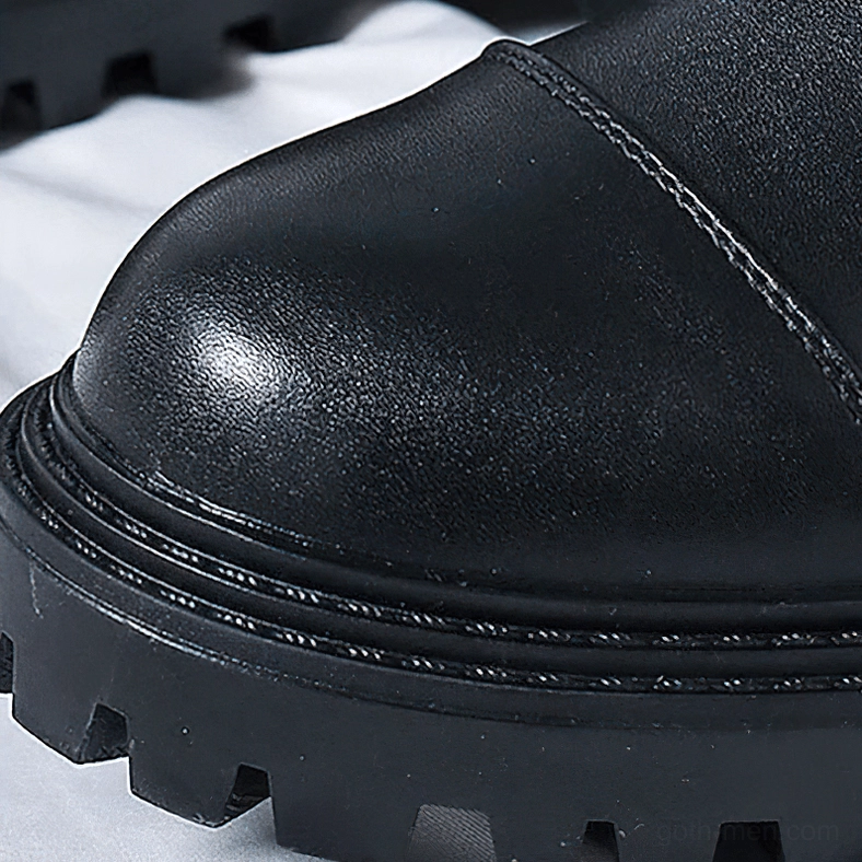 Low-angle close-up of gothic boot toe and lugged rubber sole tread