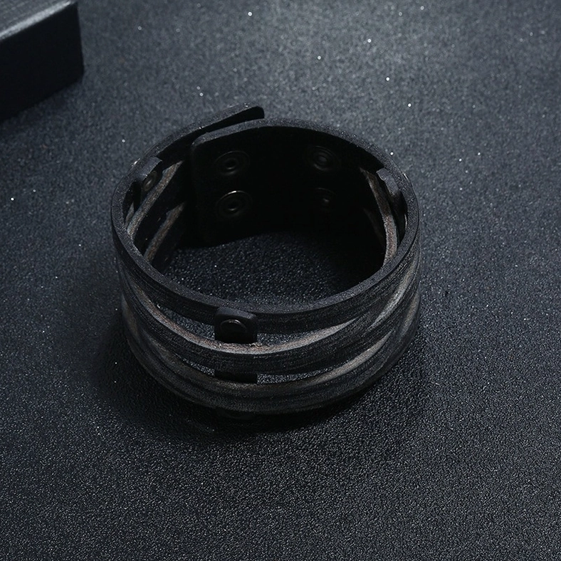 Interior close-up of black leather gothic bracelet revealing snap fastener hardware and internal construction details