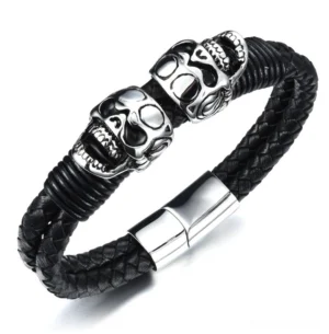 Black braided leather skull bracelet with dual stainless steel skulls, flat lay overhead view
