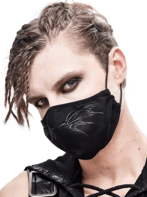 Male model wearing black gothic butterfly embroidered face mask with adjustable ear straps, three-quarter left view
