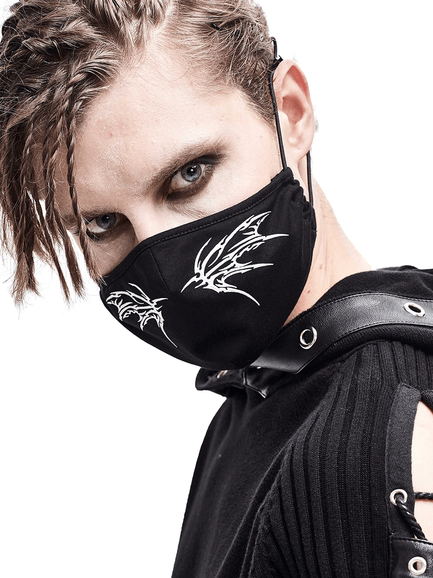 Black gothic butterfly face mask with white wing print worn by male model in studio, left side profile view showing adjustable elastic bands