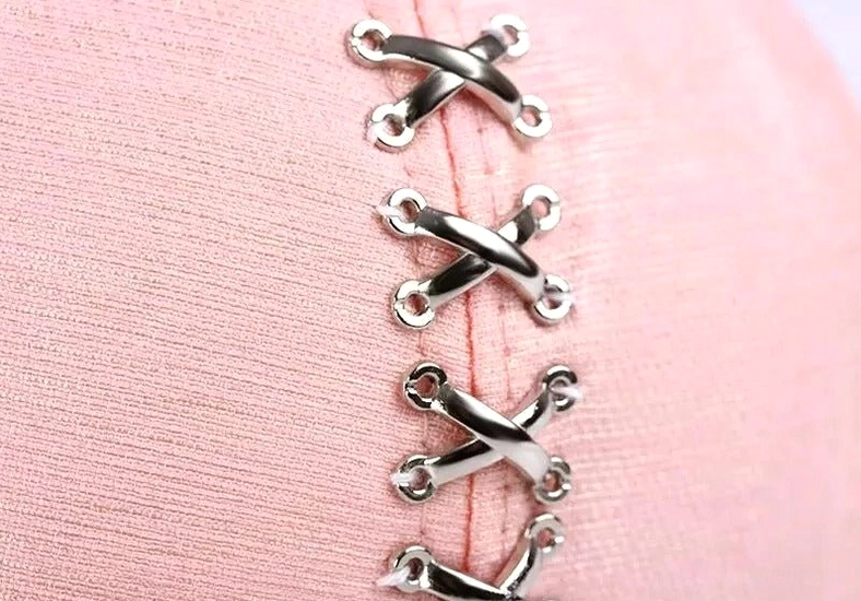 Close-up detail of cross-shaped metal buckles and side hardware on gothic baseball cap