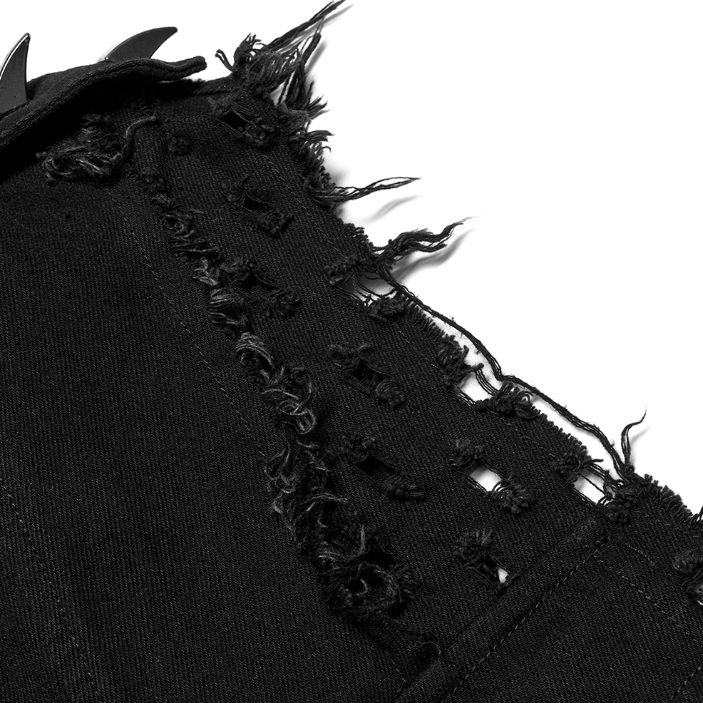 Macro close-up of distressed black fabric showing intentional cutouts and perforated mesh texture on gothic cape