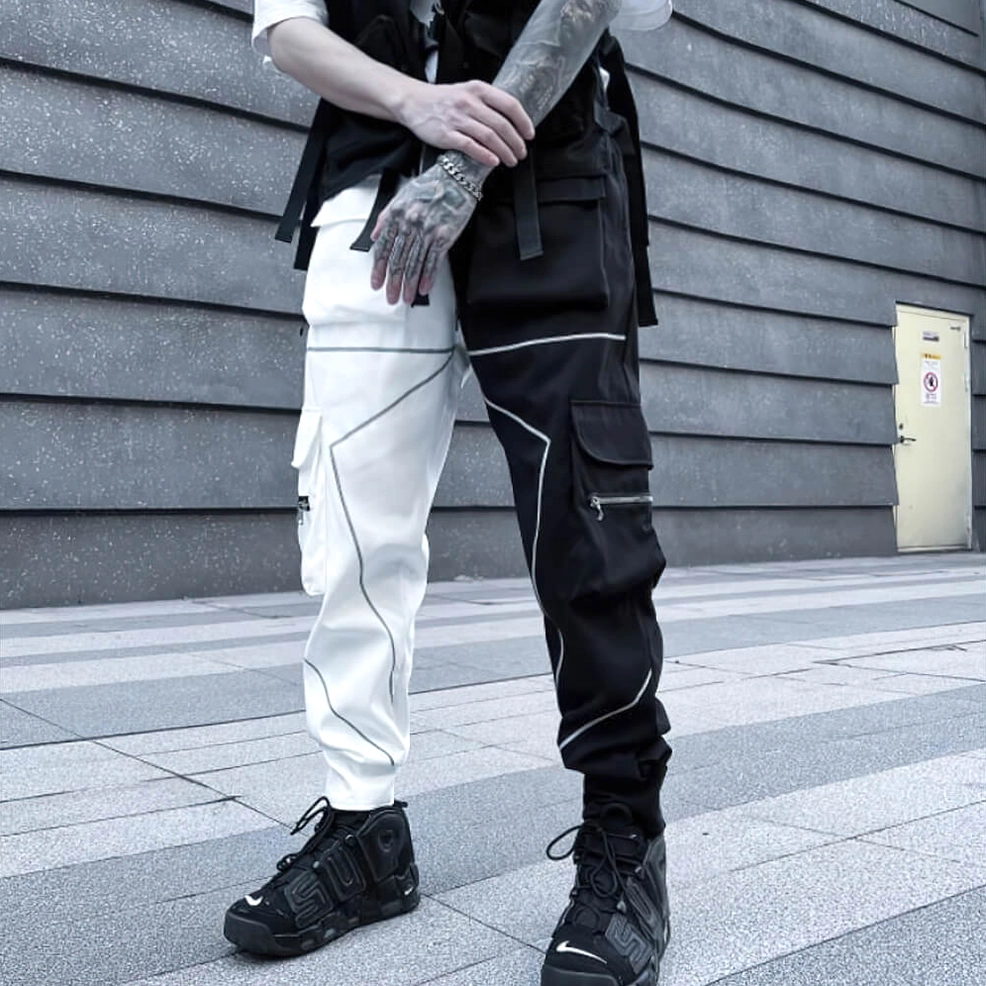 Black cargo pants close-up detail shot featuring zippered pockets and reflective piping design