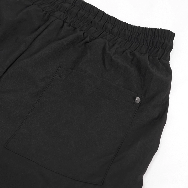 Rear waist area of black gothic cargo trousers with elasticated waistband and riveted patch pocket