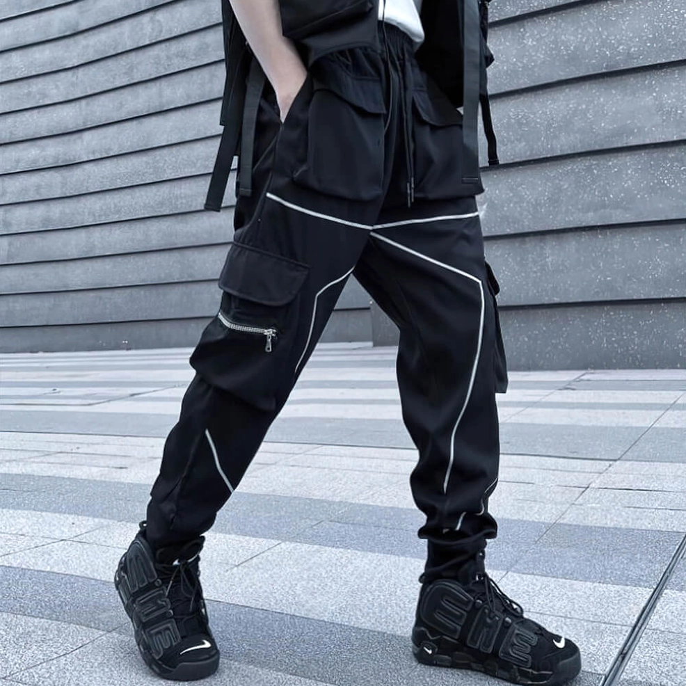 Black cargo pants three-quarter side view with reflective piping, tactical webbing, and elastic cuffs