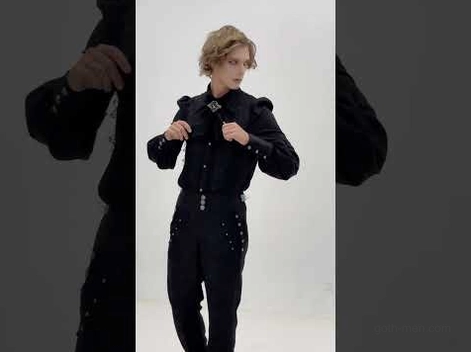 Black gothic cargo pants styled with ruffled Victorian shirt on male model