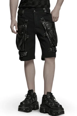 Front view of black gothic cargo shorts with faux leather trim and oversized 3D pockets on male model