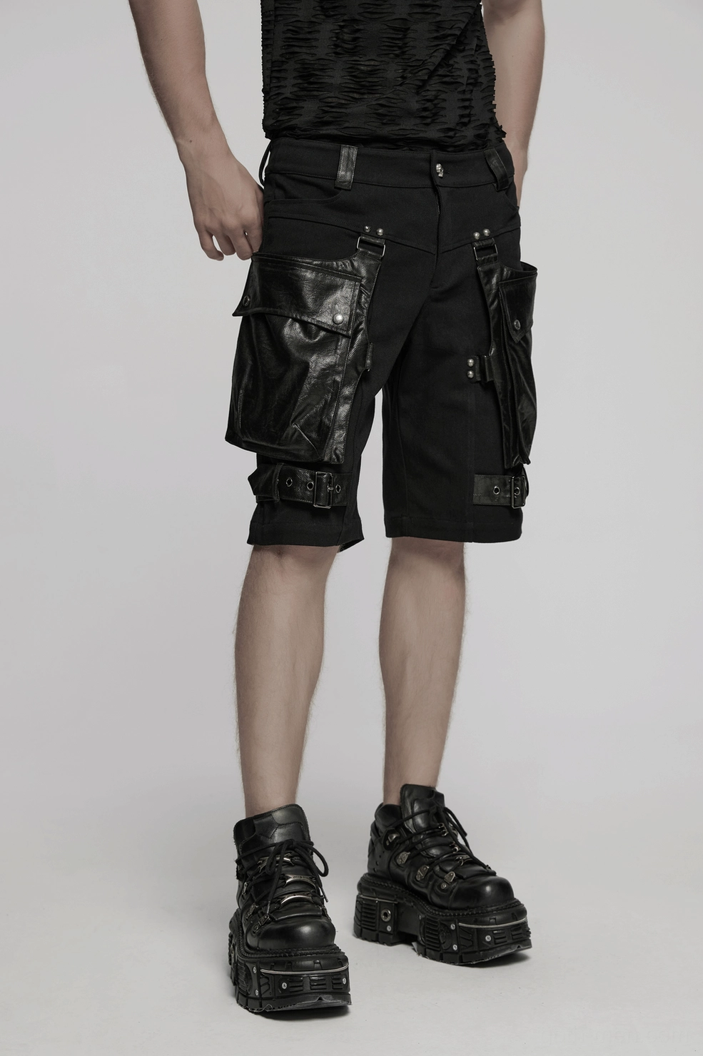 Styled product shot of gothic cargo shorts displaying complete pocket system and decorative leg straps