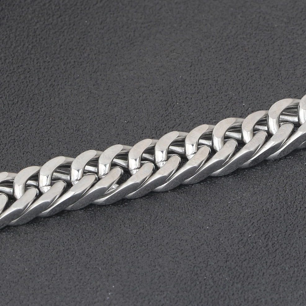 Close-up macro shot of twisted stainless steel curb chain links showing flat twisted texture detail