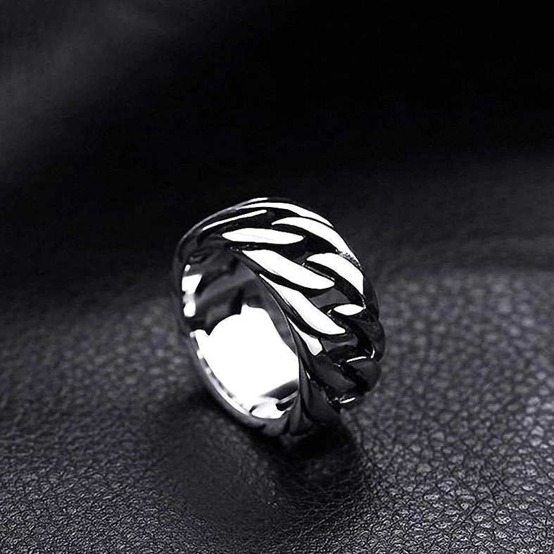 Dark silver gothic hollow woven chain ring on fine grain black leather background