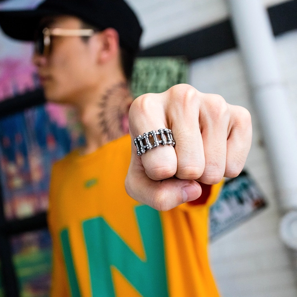 Vintage silver chain ring on male hand fist close-up indoors, showing gothic alternative aesthetic and everyday wearability