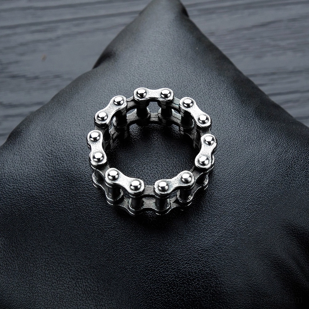 Polished silver stainless steel gothic chain ring flat lay on black leather, showing hollow link construction