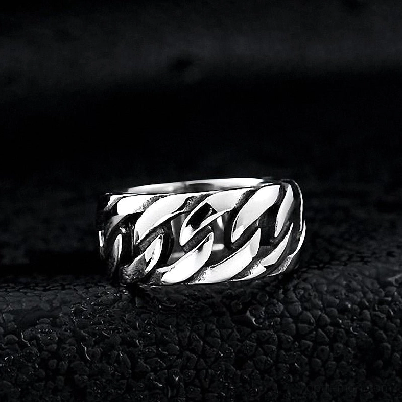 Polished silver gothic curb chain link ring with flat texture on black bumpy leather