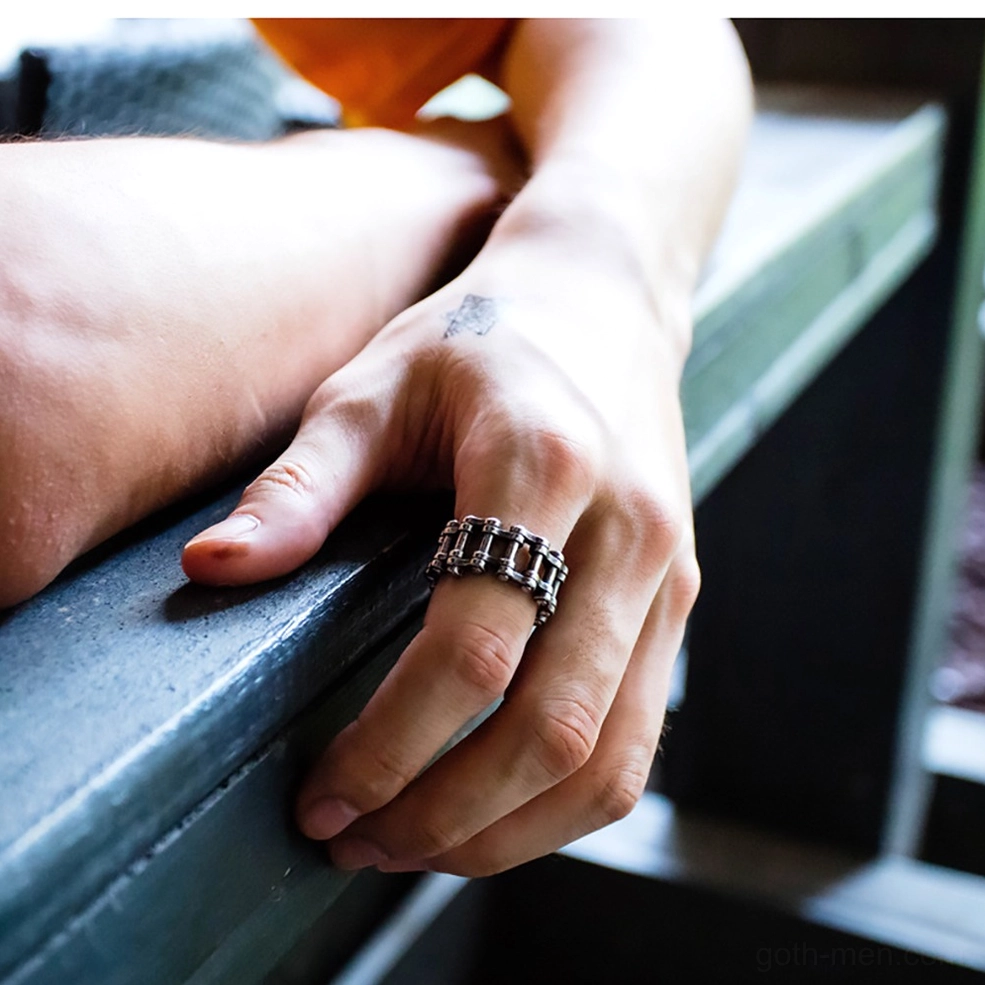 Man wearing gothic chain ring on index finger outdoors, demonstrating fit and punk rock style statement jewelry