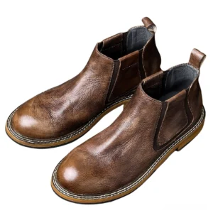 Distressed brown leather Chelsea boots with round toe and stitched rubber outsole, three-quarter flat angle