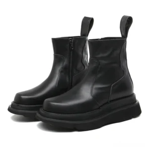 Black leather Chelsea boots with chunky platform heel, three-quarter front view showing side zipper and thick sole