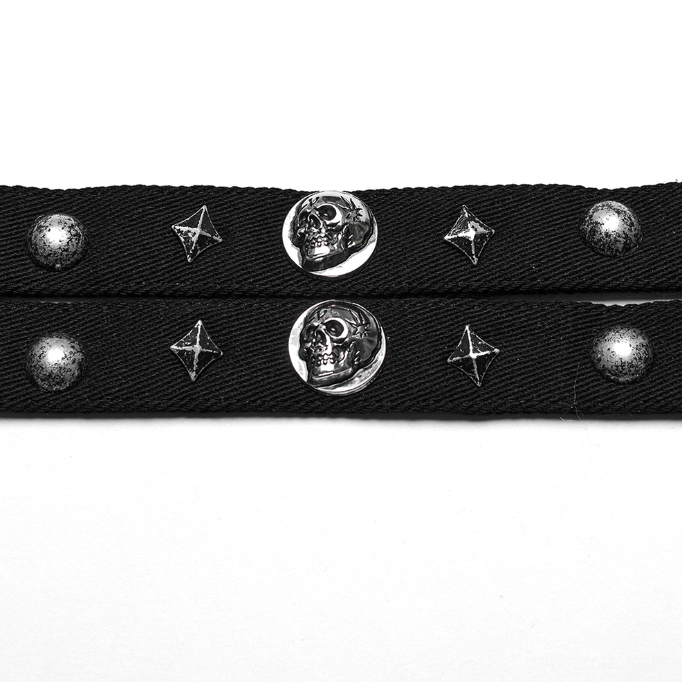 Close-up detail of black choker strap showing silver skull, four-pointed star, and round metal studs on woven fabric