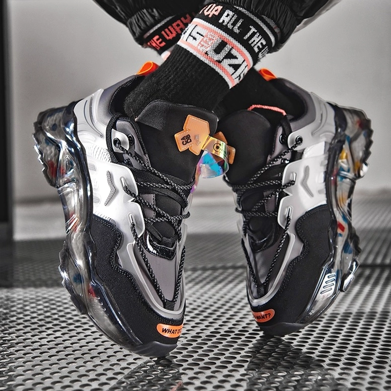 Black gothic chunky sneaker front angle showcasing color-block upper with orange accent and bold alternative footwear statement