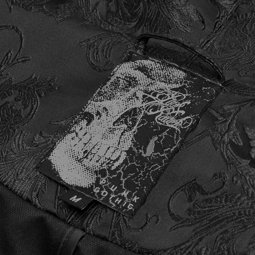 Close-up view of Gothic cloak label tag showing skull print branding, punk-goth aesthetic, and size marker on jacquard fabric
