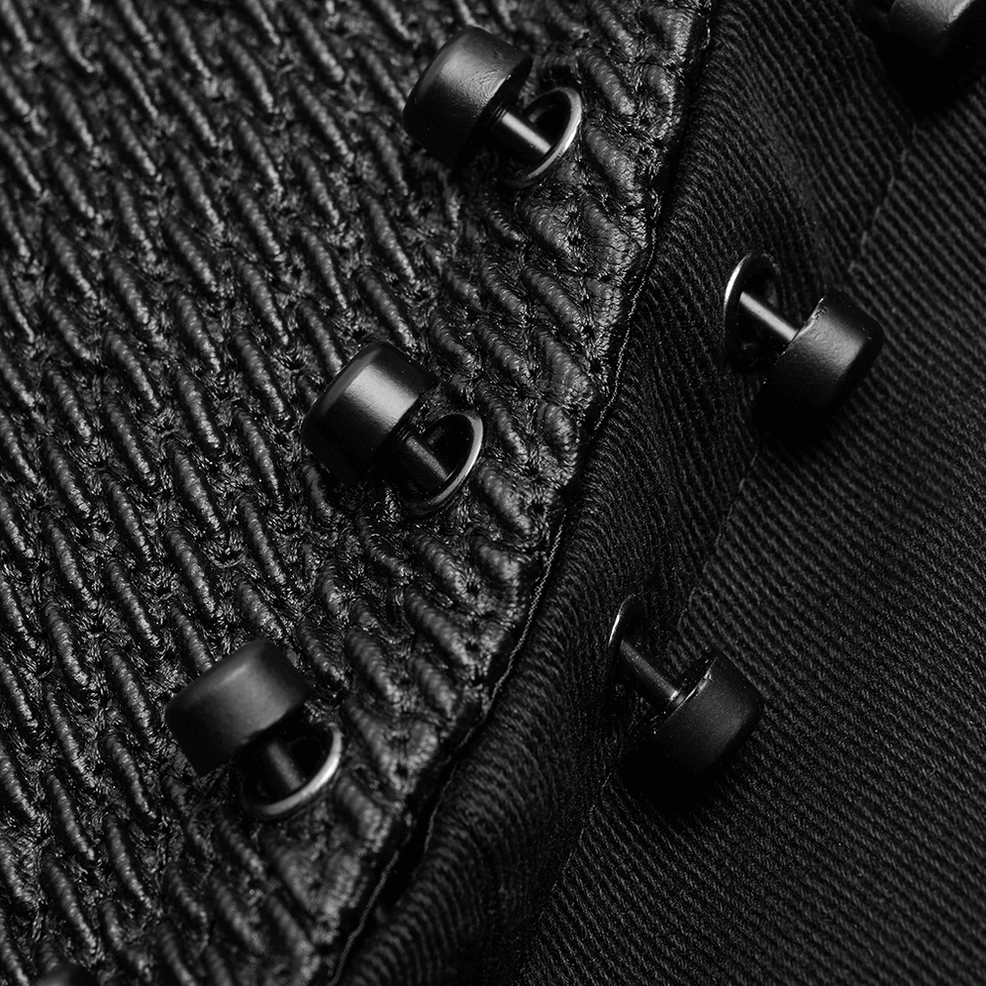 Close-up detail of black gothic coat fabric texture showing woven cotton twill and metal stud fasteners