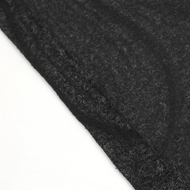Fabric close-up showing dark marbled knit pattern and folded edge finishing technique
