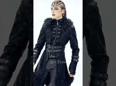 Male goth model wearing cracked faux leather trench coat with layered waist straps, faux fur collar and dramatic hood in dark studio setting