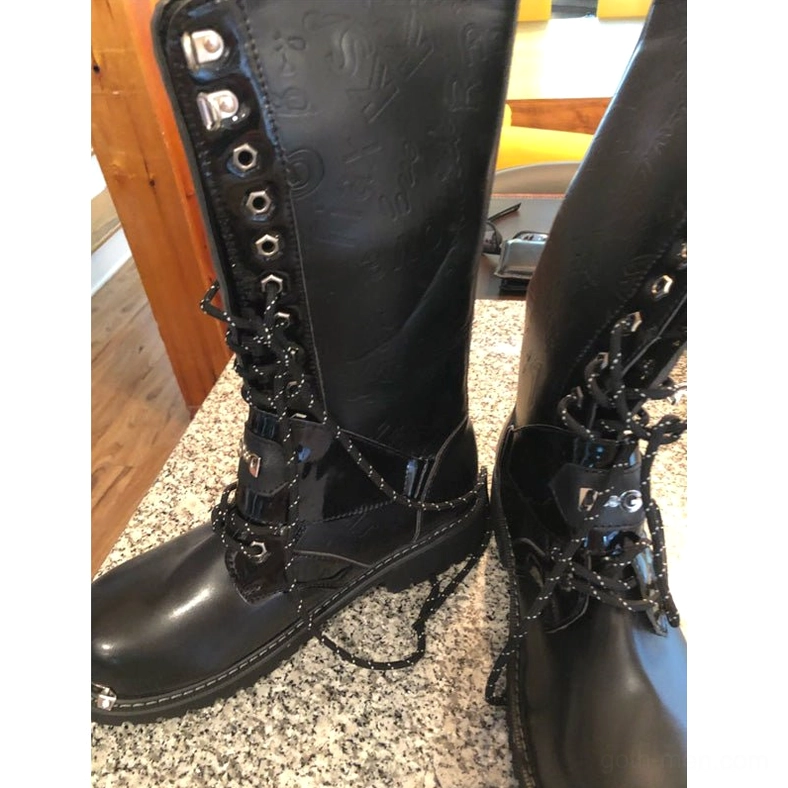Comprehensive view of black gothic combat boots highlighting design features, metal chain placements, and overall silhouette for festival and club wear