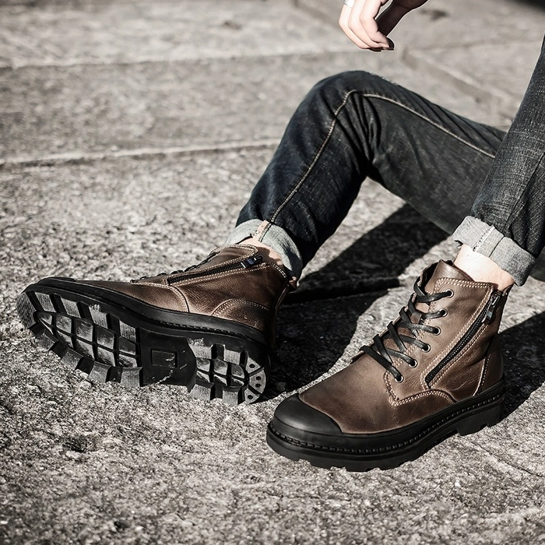 Black and taupe genuine leather gothic combat boots with round toe profile and low heel height on white background