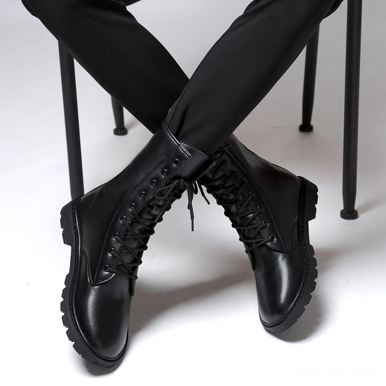 Model wearing black gothic lace-up combat boots seated – men's leather boots styled with formal trousers