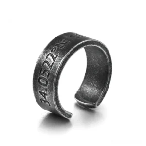 Dark aged stainless steel open cuff coordinate ring with engraved inscription, left oblique view on white studio background
