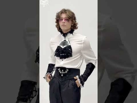 Male model styling gothic corset belt with formal dark outfit and gothic makeup aesthetic