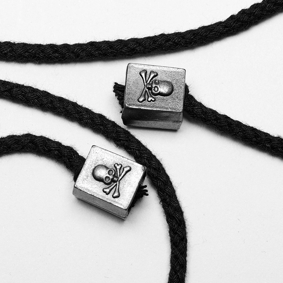 Detailed macro shot of skull crossbone pendants and braided drawstring on gothic corset belt back