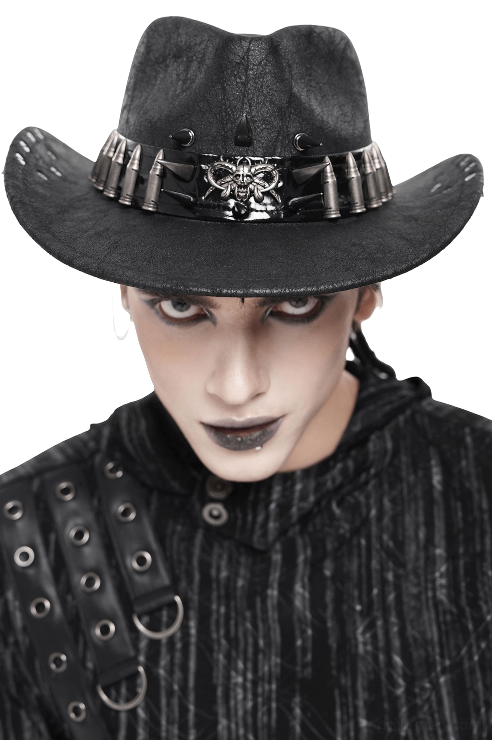Black gothic cowboy hat with metal spike and bullet stud trim worn by male model with dark makeup, front view