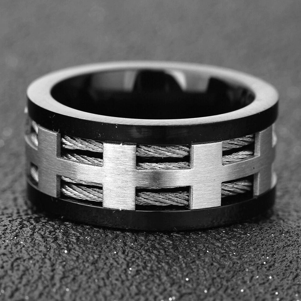 Flat front view of cross inlay gothic ring showing brushed silver parts and black border on textured background
