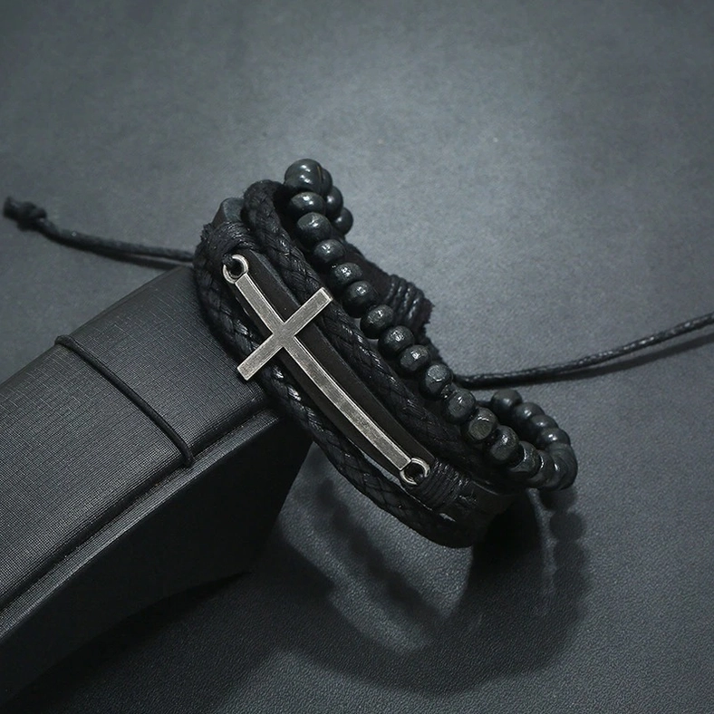 Close-up angled side view of gothic cross leather bracelet showing tie string adjustment and cross ornament details