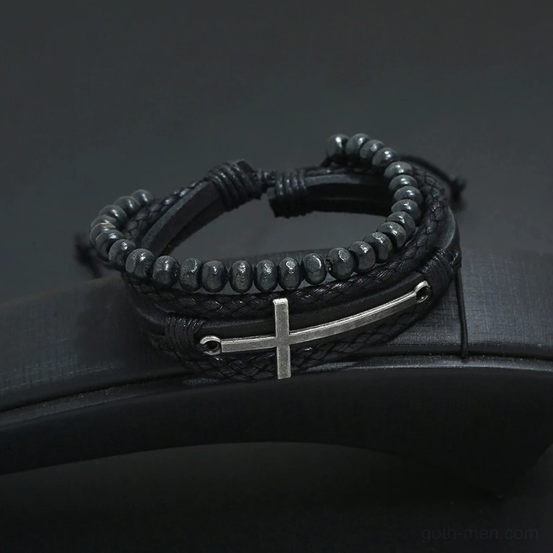 Multi-layer black gothic cross bracelet with alloy cross decoration - low angle front view on leather background