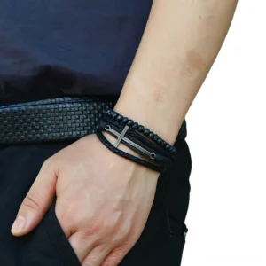 Adjustable gothic cross leather bracelet worn on male wrist - side view showing fit and styling