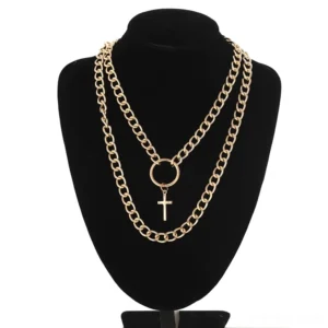 Gold layered cross chain necklace with thick curb chains and cross charm on black jewelry stand