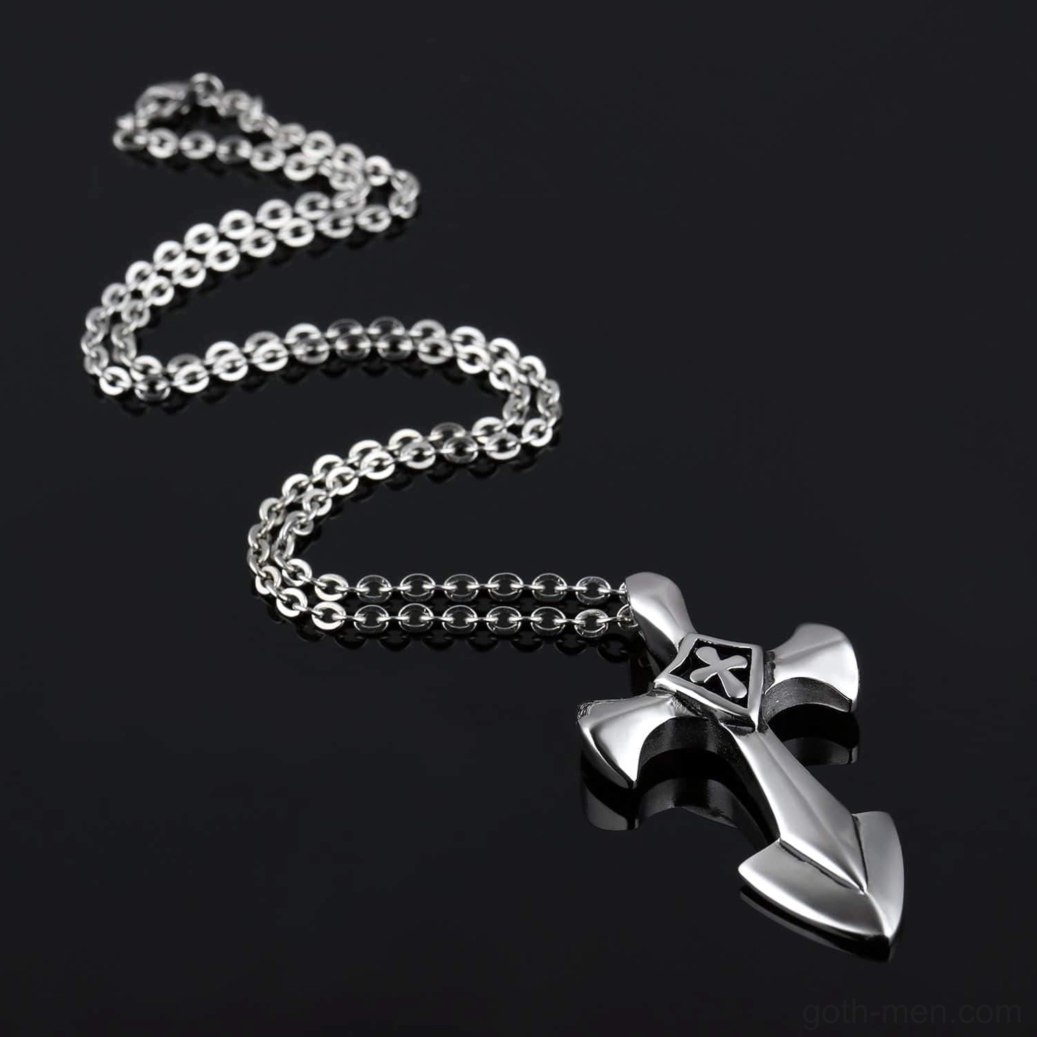 Flat lay of gothic cross pendant with 50cm link chain on black background studio setup