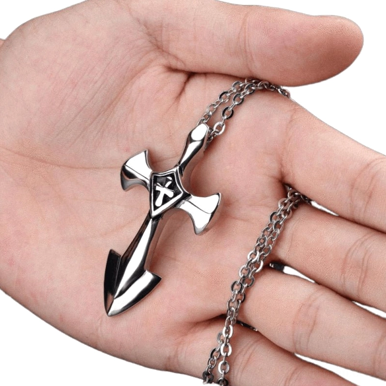 Stainless steel cross pendant held in palm showing hollow geometric design and weight