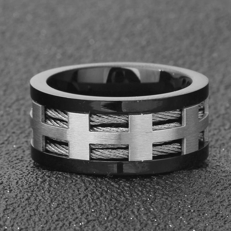 Front flat view of dual-tone gothic ring with braided wire inlay and black outer band on dark textured surface