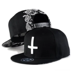 Black gothic cross embroidery snapback baseball cap front and side view with white cross detail and paisley pattern
