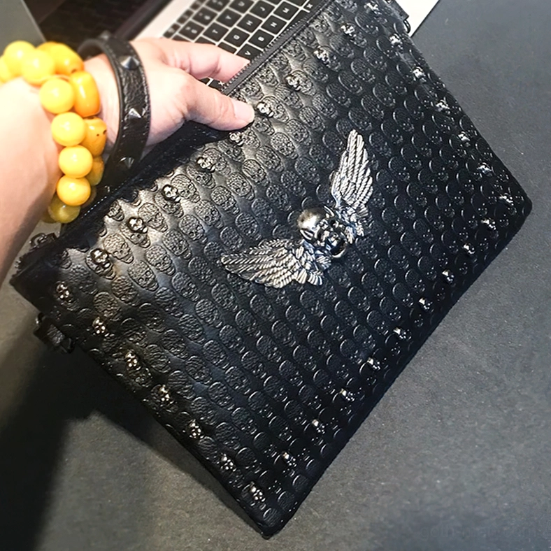 Black punk leather bag with silver skull hardware in hand - alternative style accessory