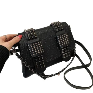 Studded gothic crossbody bag side three-quarter view worn with hand showing dual shoulder strap options