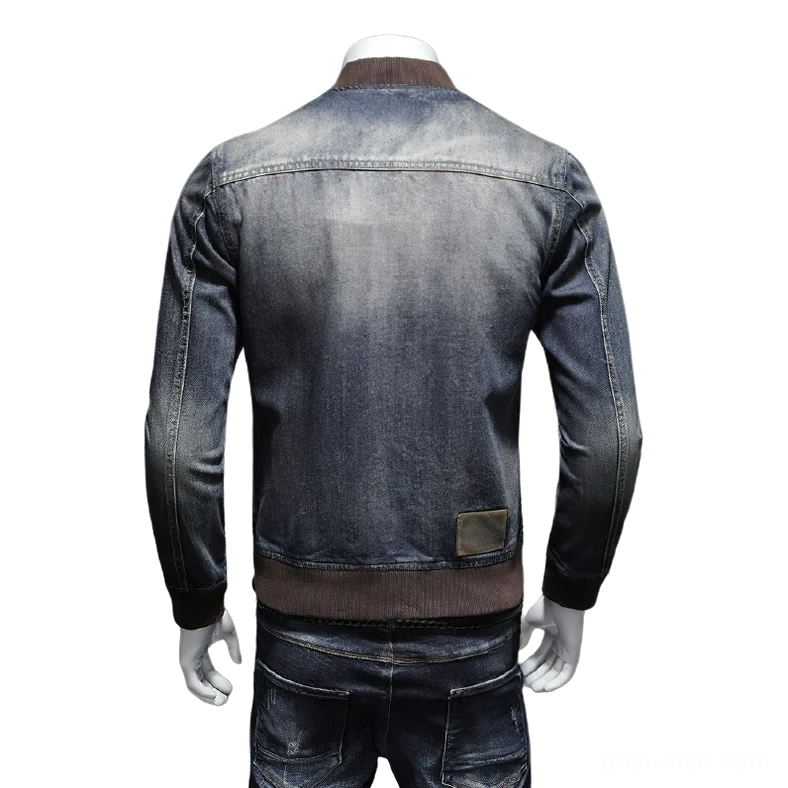 Vintage washed denim bomber jacket back view showing embossed leather brand patch and brown ribbed hem detail