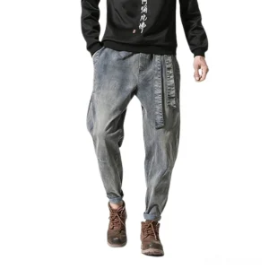 Men's moody grey loose-fit harem denim jeans with drawstring belt, full-body model view paired with brown work boots