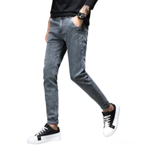 Smoky grey slim fit gothic denim jeans for men, side walking view showing tapered silhouette and stonewashed finish