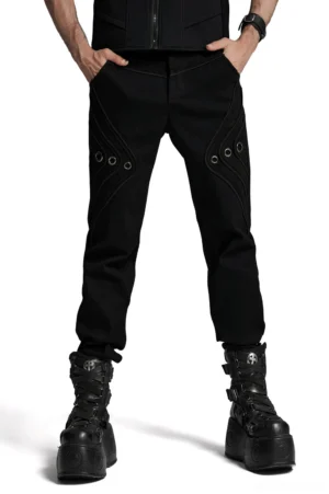 Black gothic distressed denim pants with metal eyelet details worn by male model, front view studio shot